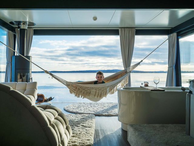 HT Houseboats Mielno – wnętrze domku na wodzie zimą z hamakiem nad jeziorem